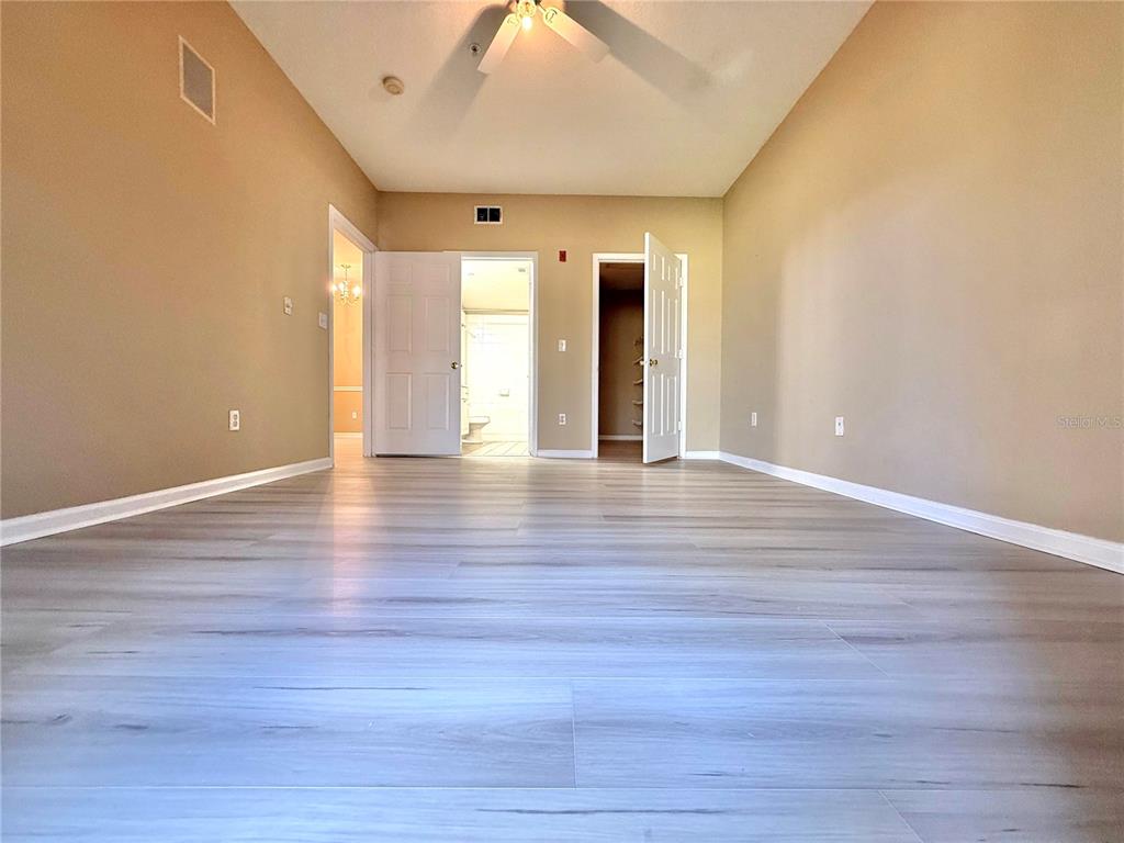 14226 Fredricksburg Drive, Unit 212 Orlando, FL 32837 - Photo 13 of 32 a view of an empty room with wooden floor and a window
