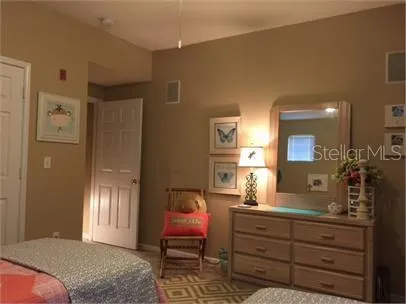 a bedroom with a bed and a mirror on dresser