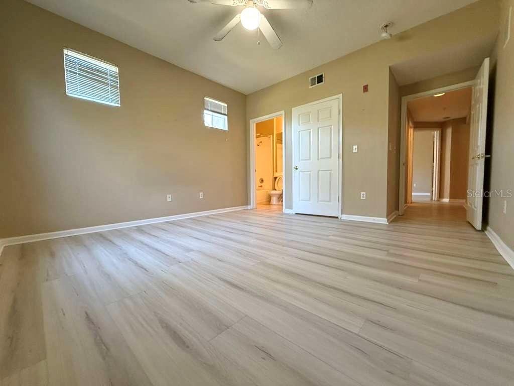 14226 Fredricksburg Drive, Unit 212 Orlando, FL 32837 - Photo 19 of 32 a view of a livingroom with wooden floor and a ceiling fan