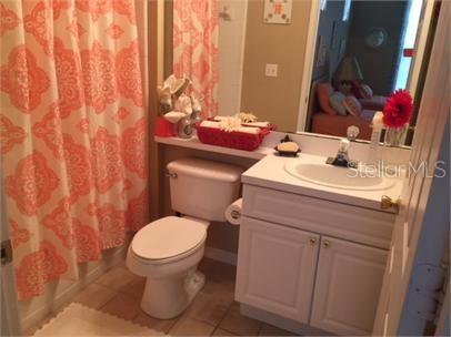 14226 Fredricksburg Drive, Unit 212 Orlando, FL 32837 - Photo 20 of 32 a bathroom with a sink toilet and mirror
