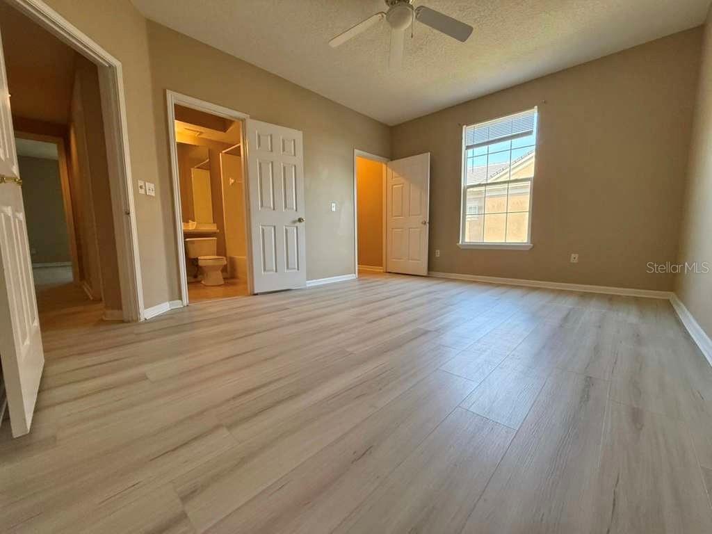 14226 Fredricksburg Drive, Unit 212 Orlando, FL 32837 - Photo 21 of 32 a view of an empty room with wooden floor and a window