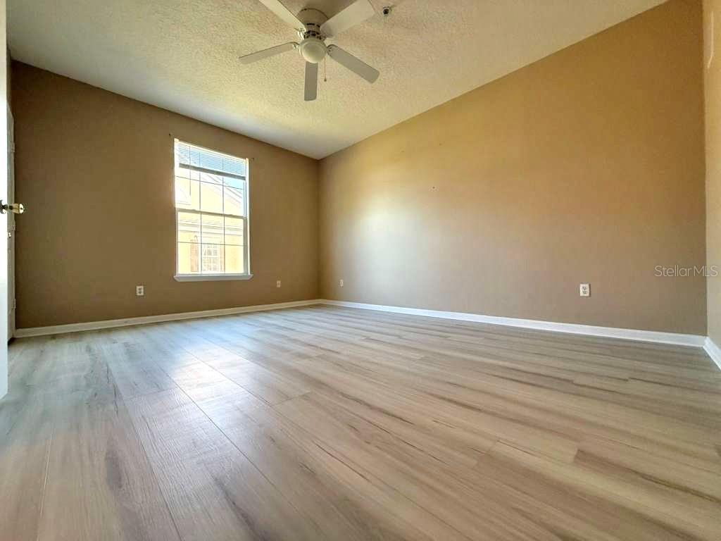 14226 Fredricksburg Drive, Unit 212 Orlando, FL 32837 - Photo 24 of 32 an empty room with wooden floor and windows