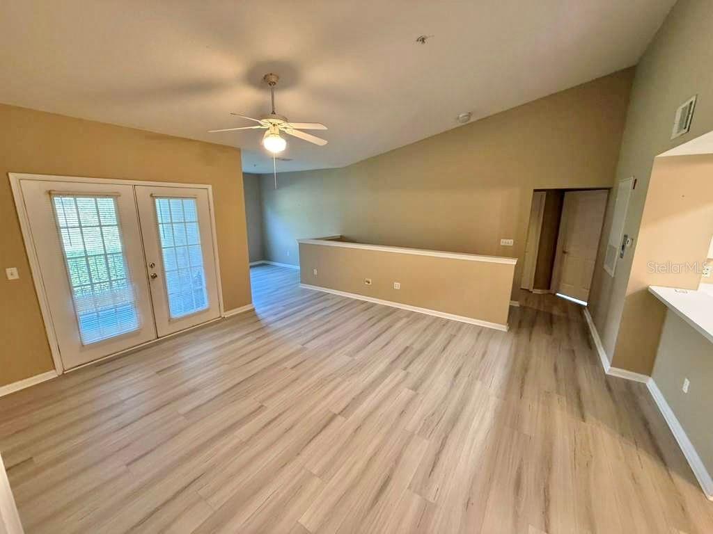 14226 Fredricksburg Drive, Unit 212 Orlando, FL 32837 - Photo 9 of 32 wooden floor in an empty room with a window