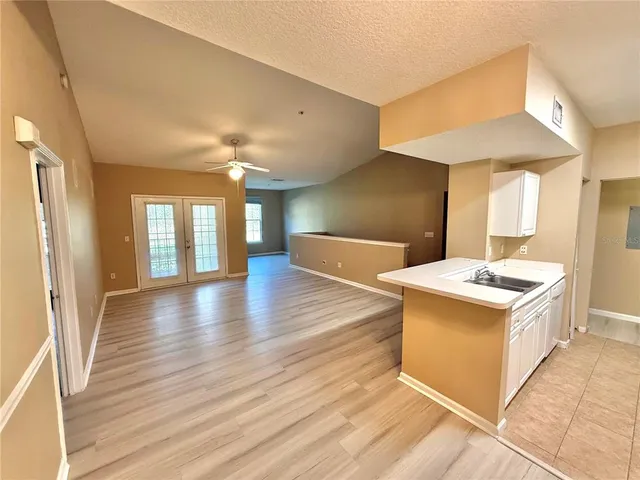 a kitchen with a stove and wooden floor
