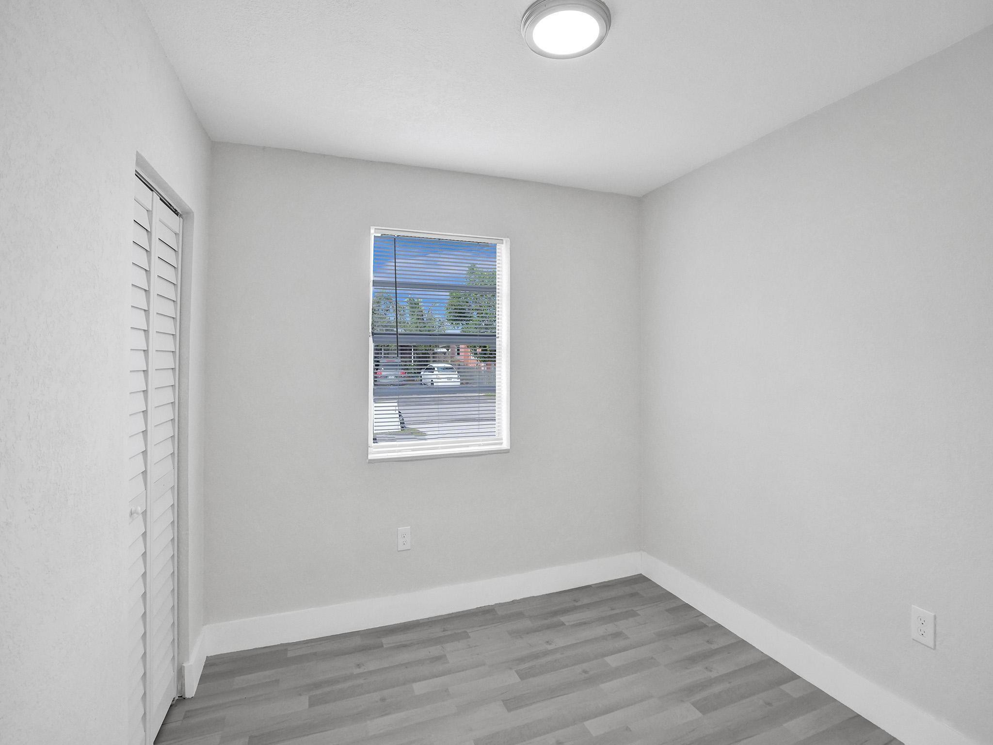 631 North 69th Terrace Hollywood, FL 33024 - Photo 17 of 60 a view of an empty room with wooden floor and a window