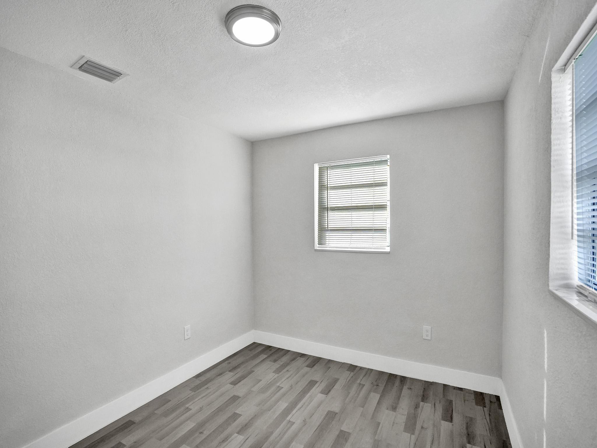 631 North 69th Terrace Hollywood, FL 33024 - Photo 21 of 60 an empty room with wooden floor and windows