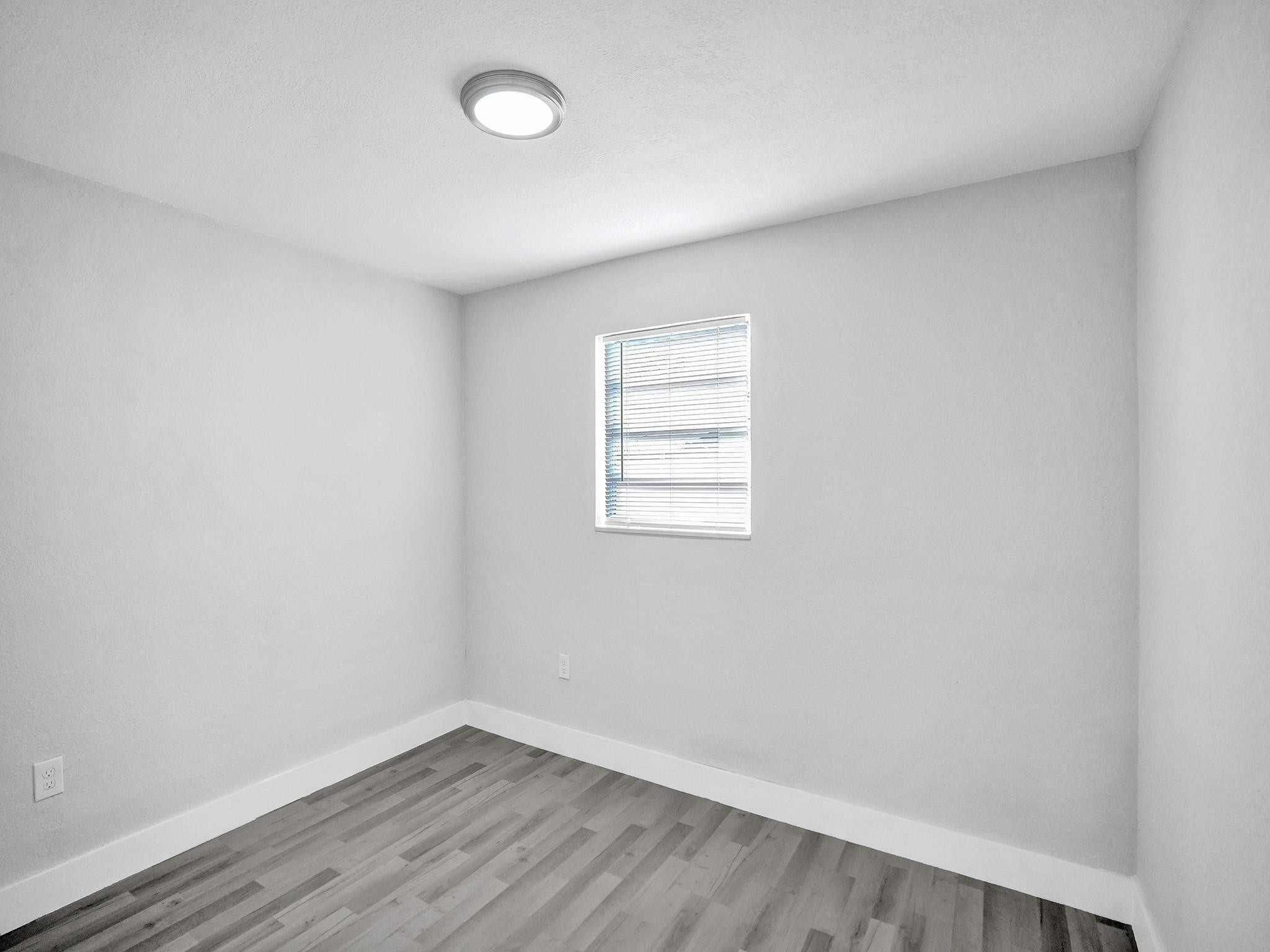 631 North 69th Terrace Hollywood, FL 33024 - Photo 27 of 60 an empty room with wooden floor and windows