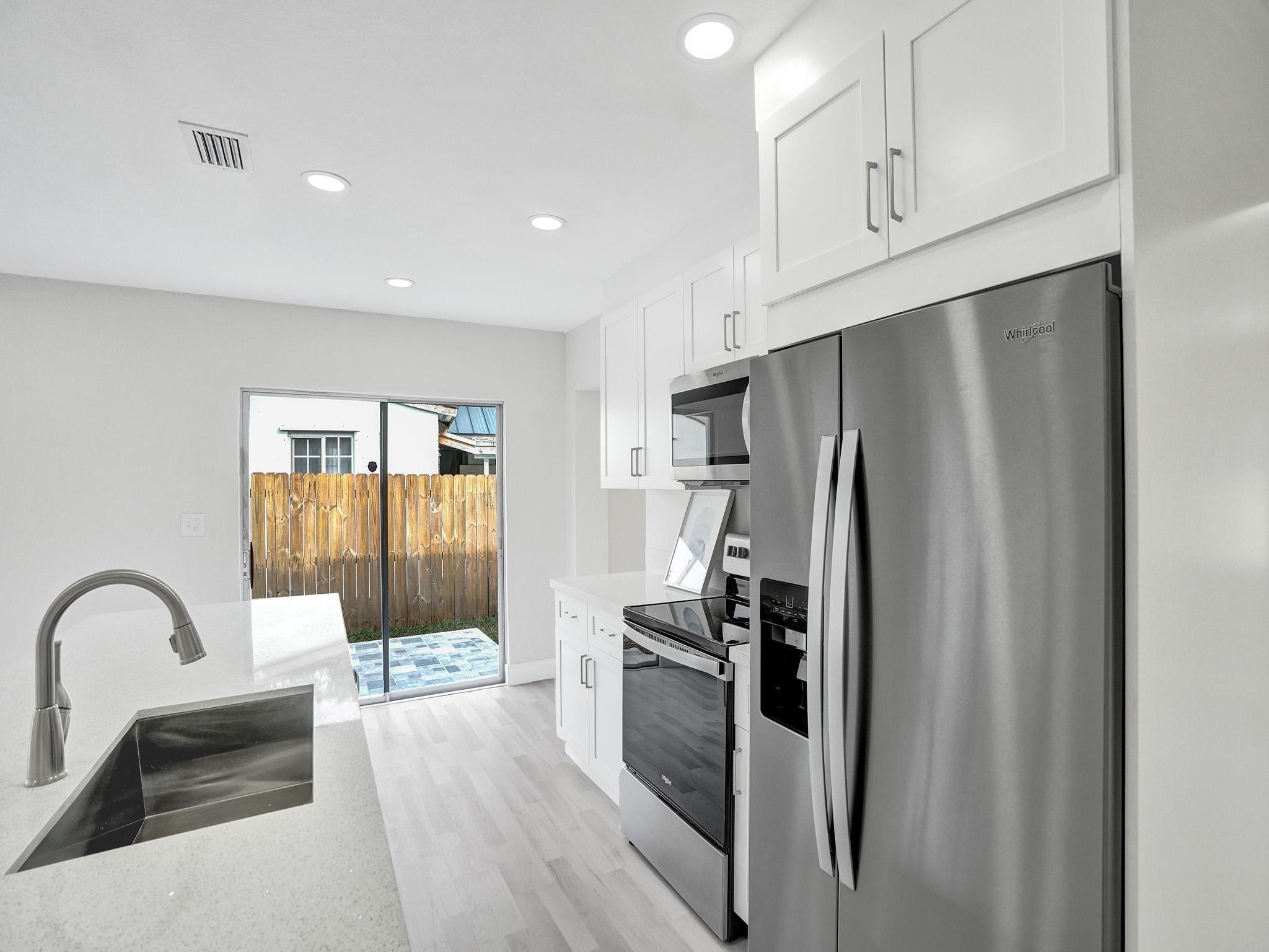 631 North 69th Terrace Hollywood, FL 33024 - Photo 47 of 60 a kitchen with stainless steel appliances a refrigerator sink and cabinets