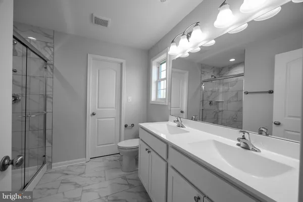 a bathroom with a double vanity sink mirror and toilet