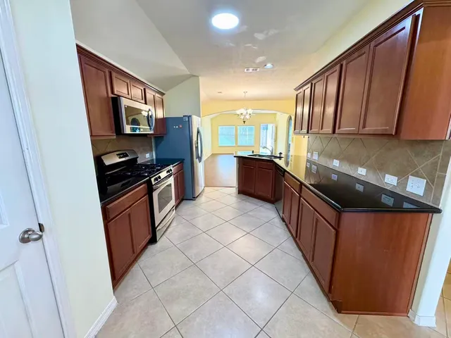 a kitchen with stainless steel appliances a sink stove and cabinets