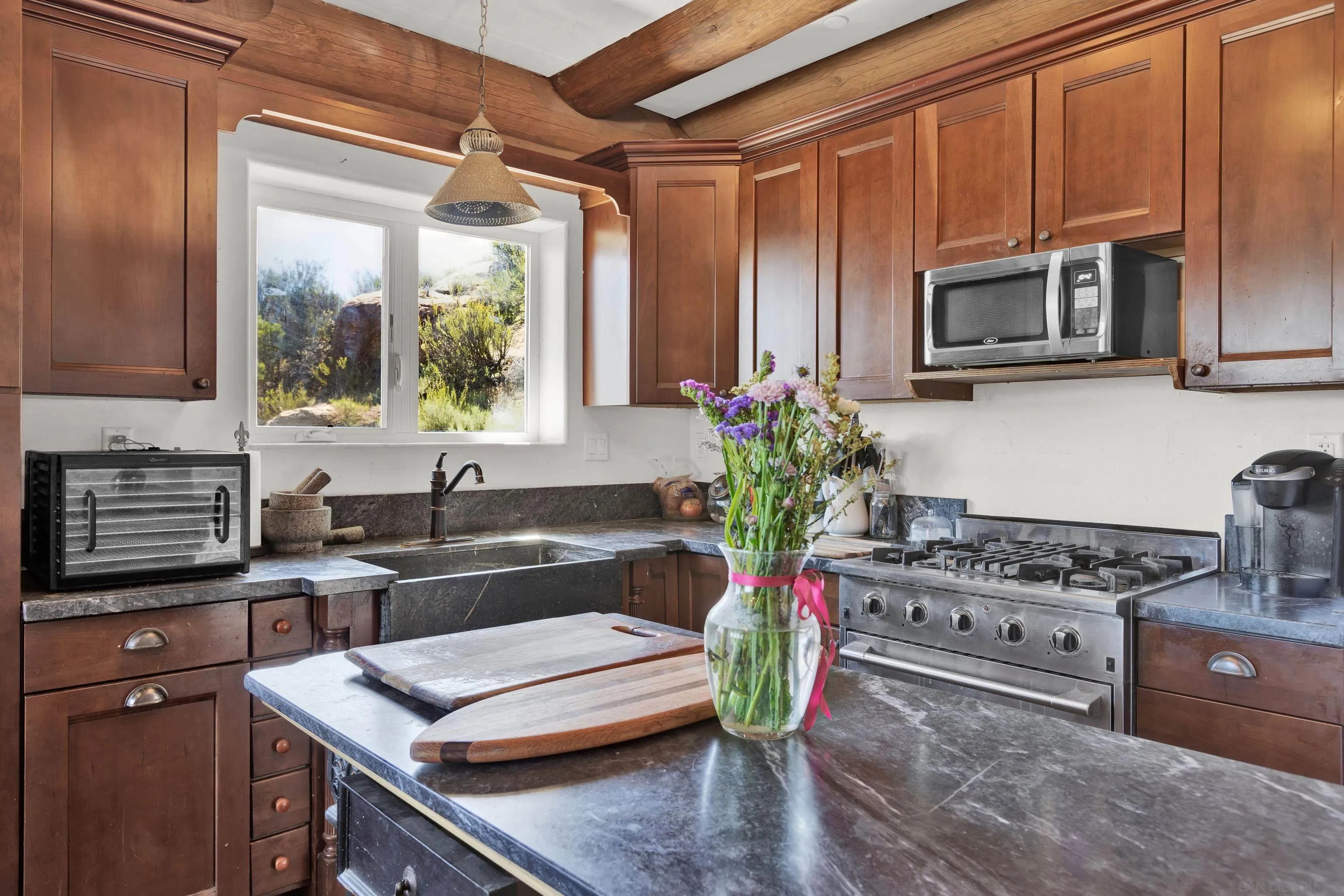 20580 Bexley Road Jamul, CA 91935 - Photo 18 of 50 a kitchen with stainless steel appliances kitchen island granite countertop a stove a sink and a microwave