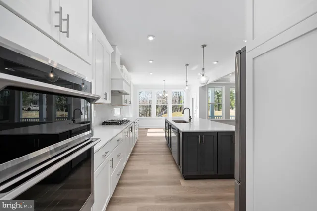 a view of an empty room with wooden floor and a fireplace