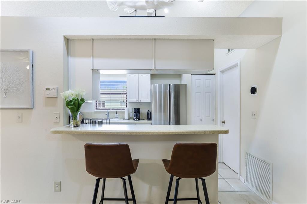 633 91st Avenue North Naples, FL 34108 - Photo 11 of 25 a kitchen with stainless steel appliances a sink and cabinets