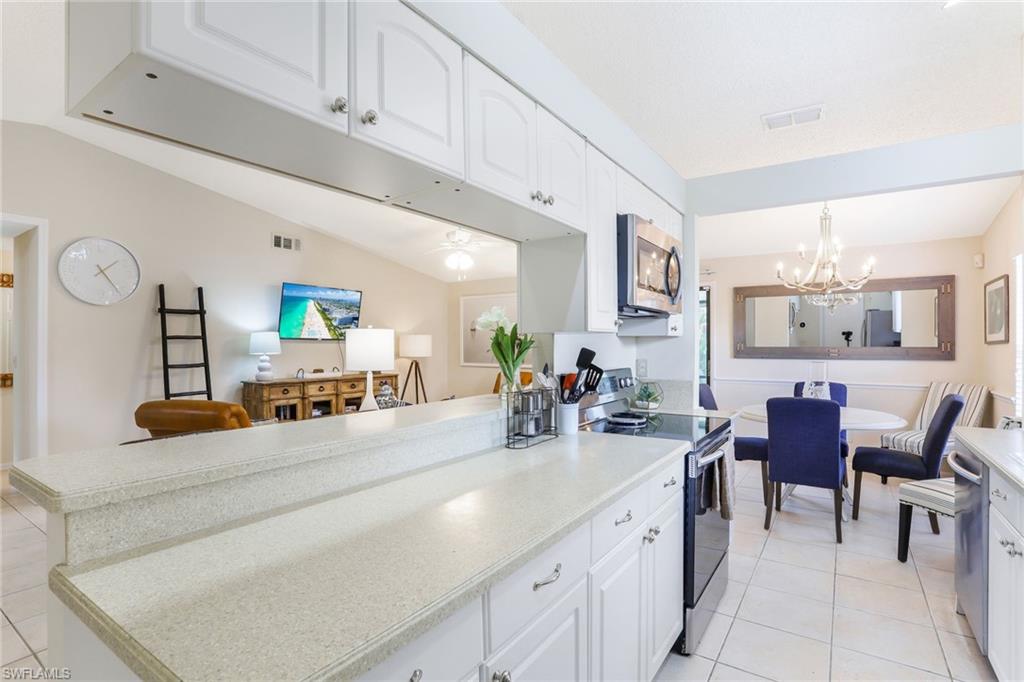 633 91st Avenue North Naples, FL 34108 - Photo 12 of 25 a kitchen with cabinets and chairs