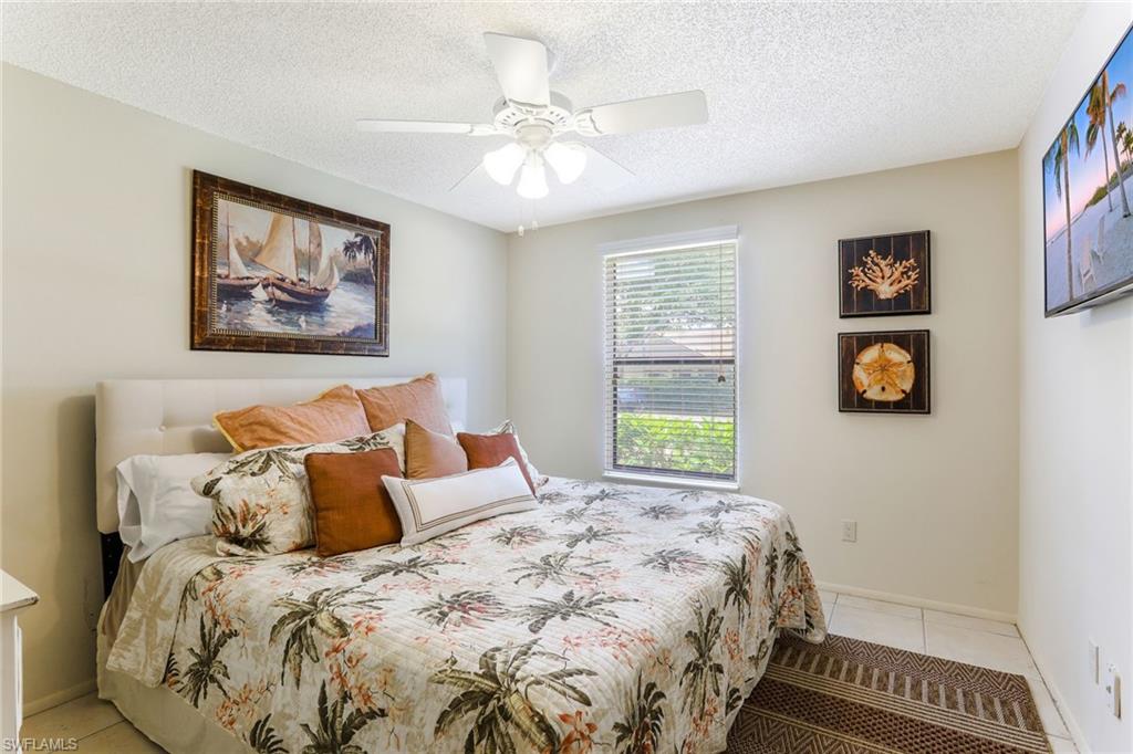 633 91st Avenue North Naples, FL 34108 - Photo 15 of 25 a bedroom with a bed and a painting on the wall