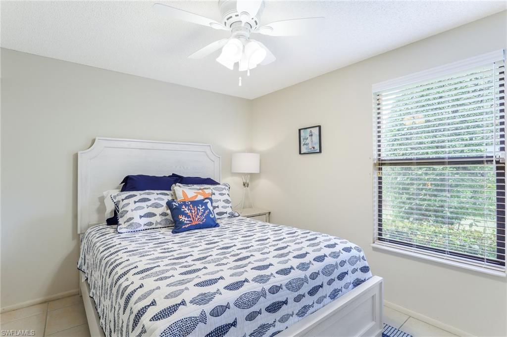 633 91st Avenue North Naples, FL 34108 - Photo 18 of 25 a bedroom with a large bed and a chandelier