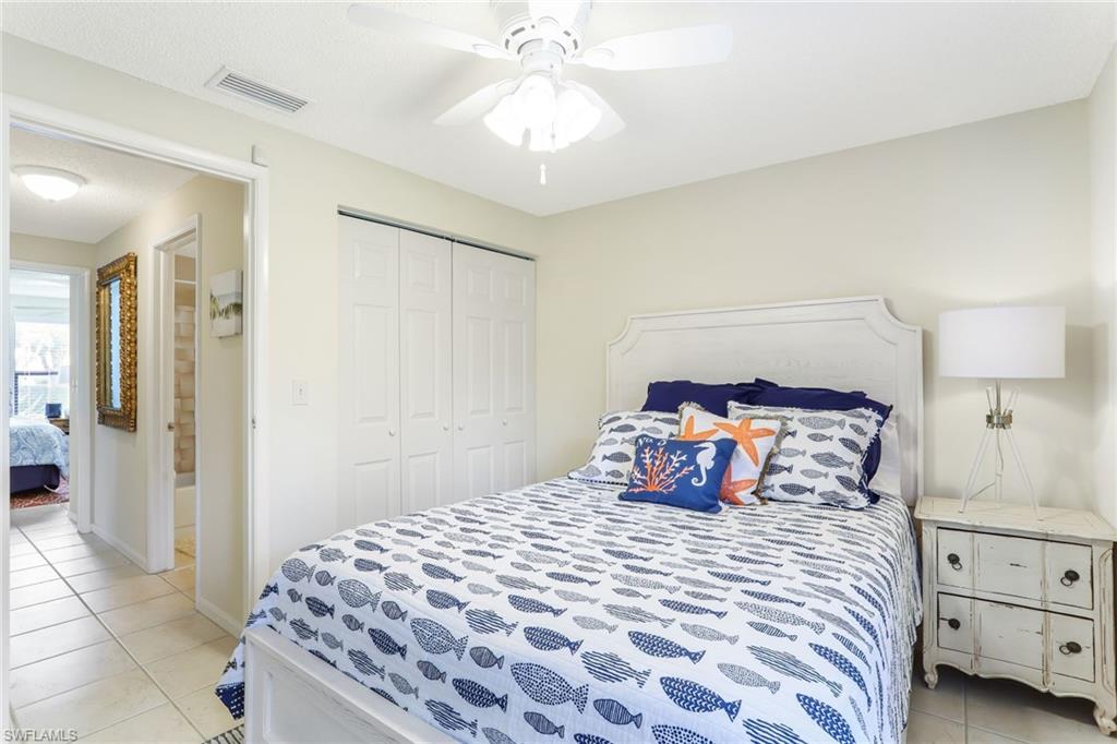 633 91st Avenue North Naples, FL 34108 - Photo 19 of 25 a bedroom with a large bed and a chandelier