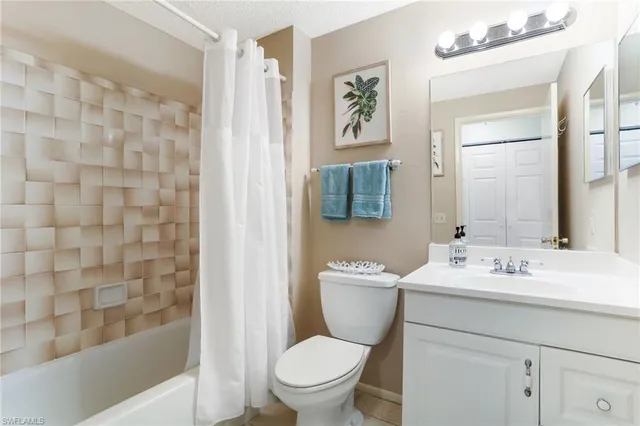 a bathroom with a sink a toilet and shower curtain
