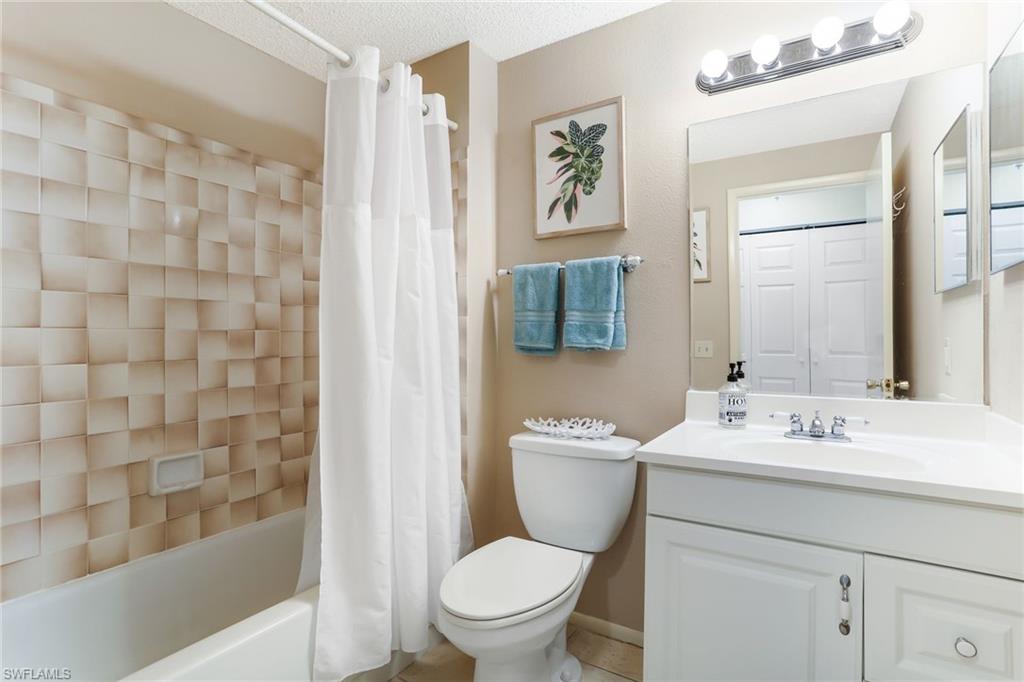 633 91st Avenue North Naples, FL 34108 - Photo 20 of 25 a bathroom with a sink a toilet and shower curtain