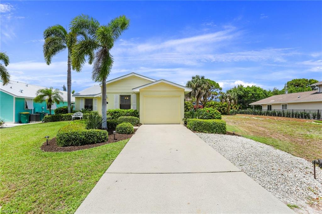 633 91st Avenue North Naples, FL 34108 - Photo 2 of 25 a front view of a house with a yard and garage