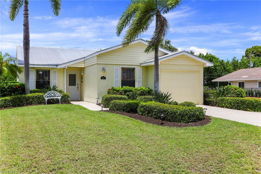 633 91st Avenue North Naples, FL 34108 - Photo 3 of 25 a front view of a house with a garden