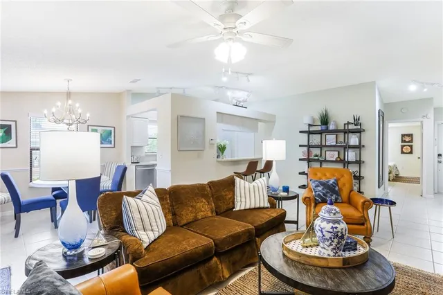 a living room with furniture a dining table and a chandelier
