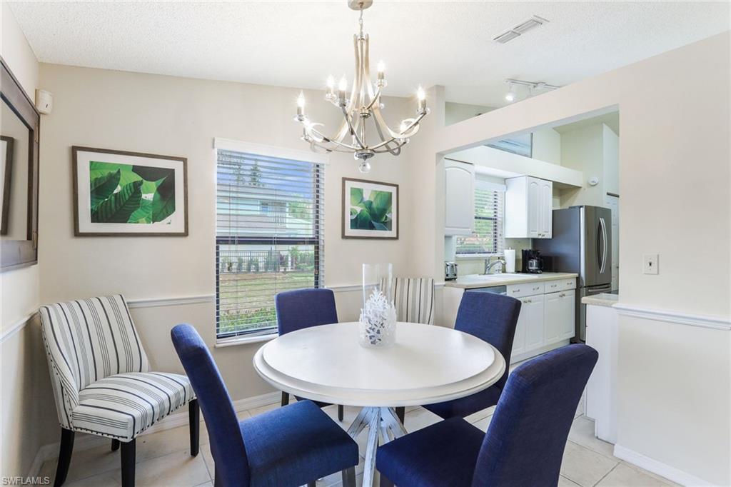 633 91st Avenue North Naples, FL 34108 - Photo 10 of 25 a view of a dining room with furniture a chandelier and window