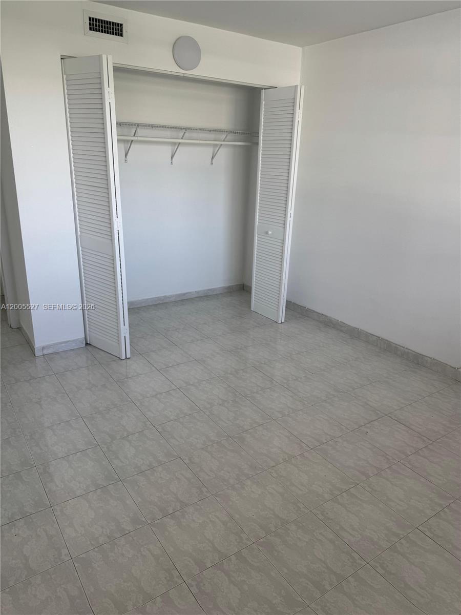 6725 Harding Avenue, Unit 503 Miami Beach, FL 33141 - Photo 5 of 23 an empty room with closet and wooden door