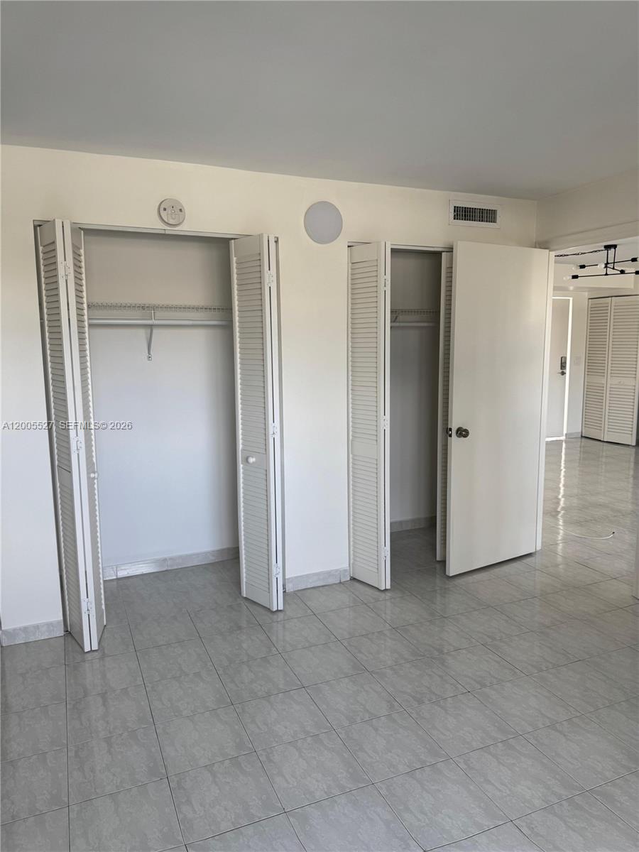 6725 Harding Avenue, Unit 503 Miami Beach, FL 33141 - Photo 7 of 23 an empty room with closet and a refrigerator