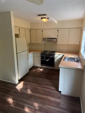 a kitchen with a refrigerator and a stove