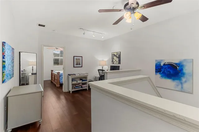 a view of a hallway with wooden floor and windows