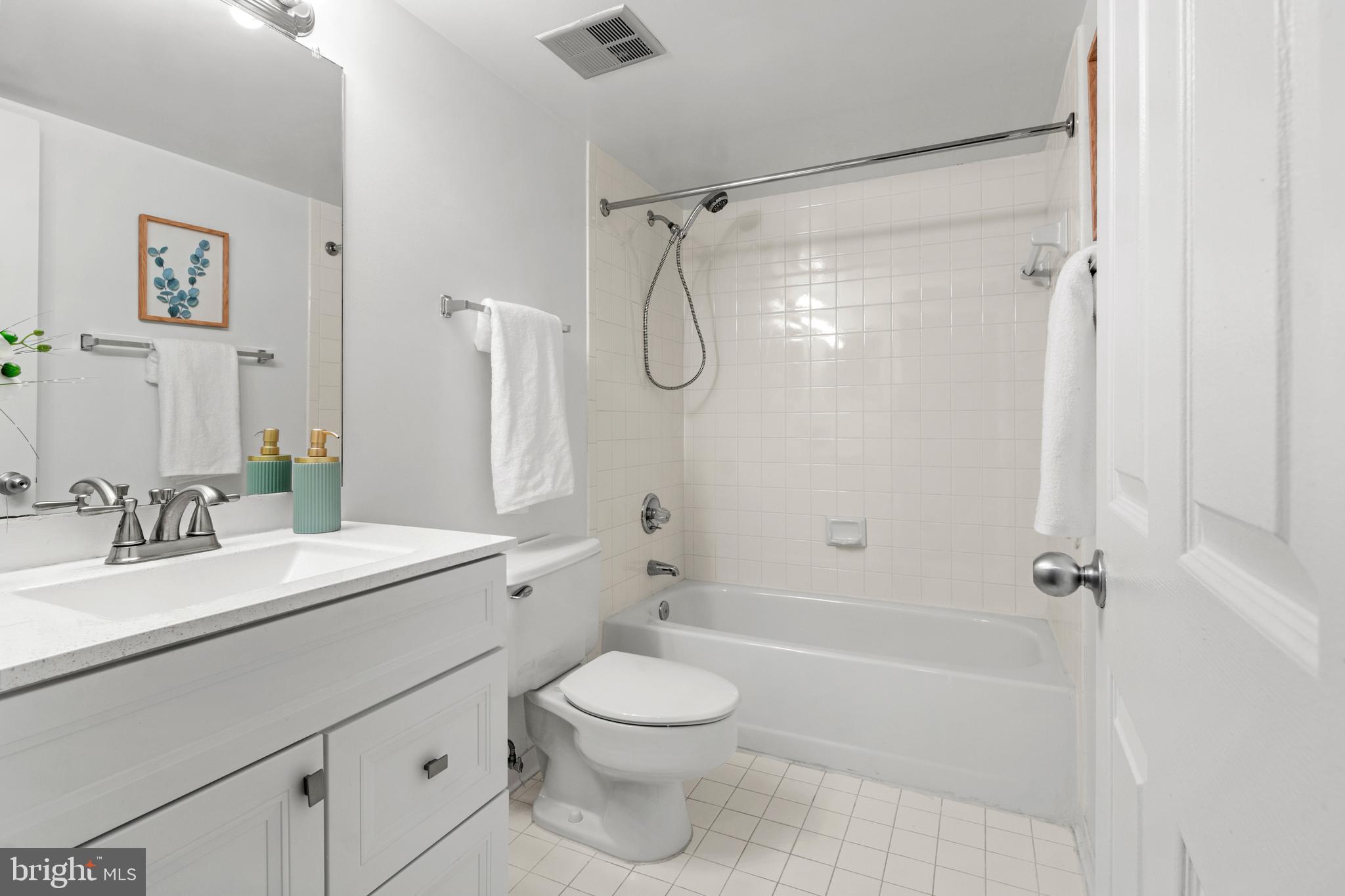 2901 Fallstaff Road, Unit 305 Baltimore, MD 21209 - Photo 12 of 13 a bathroom with a granite countertop sink a toilet and shower
