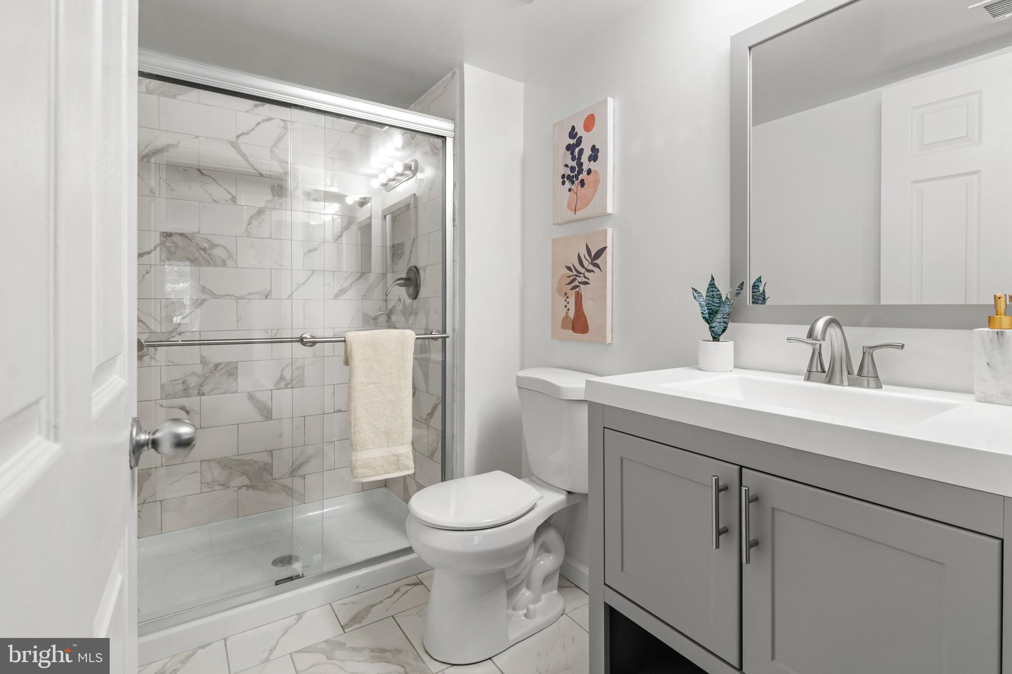 2901 Fallstaff Road, Unit 305 Baltimore, MD 21209 - Photo 10 of 13 a bathroom with a shower sink vanity mirror and toilet