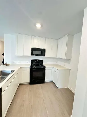 a kitchen with a white stove top oven and cabinets