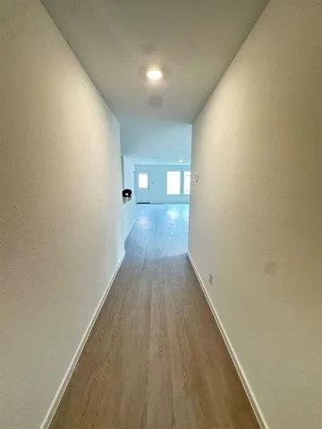 a view of a hallway with wooden floor