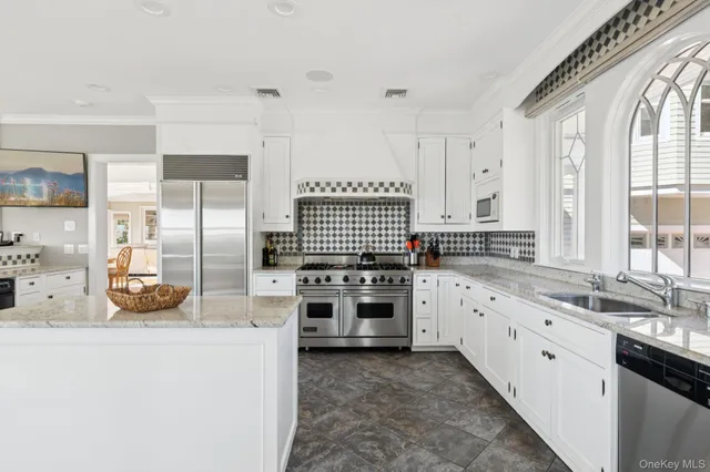 a kitchen with stainless steel appliances granite countertop a stove a sink and a refrigerator