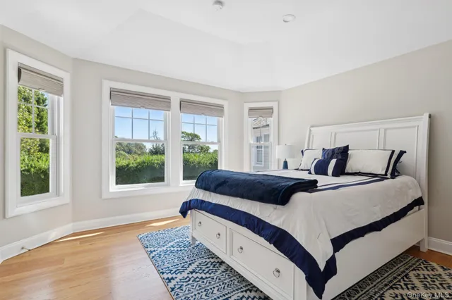 a bedroom with a bed and large windows