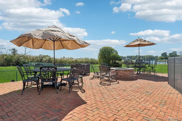 a view of a patio with a table chairs and a barbeque