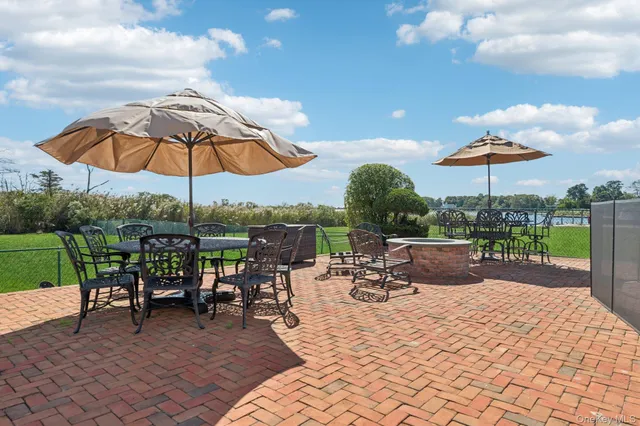 a view of a patio with a table chairs and a barbeque