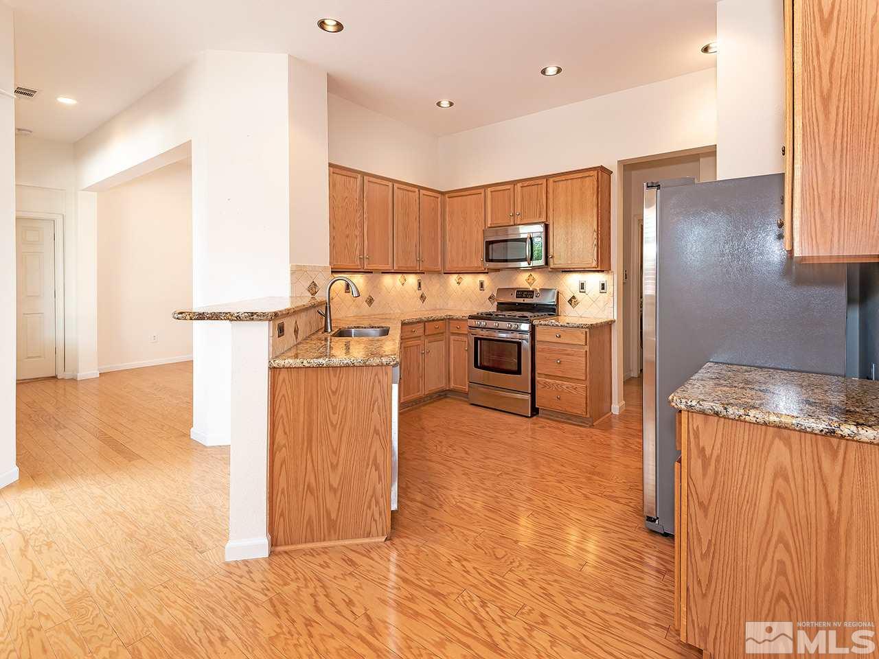 10440 Silver Rush Court Reno, NV 89521 - Photo 7 of 22 a kitchen with stainless steel appliances granite countertop a refrigerator a stove and a sink