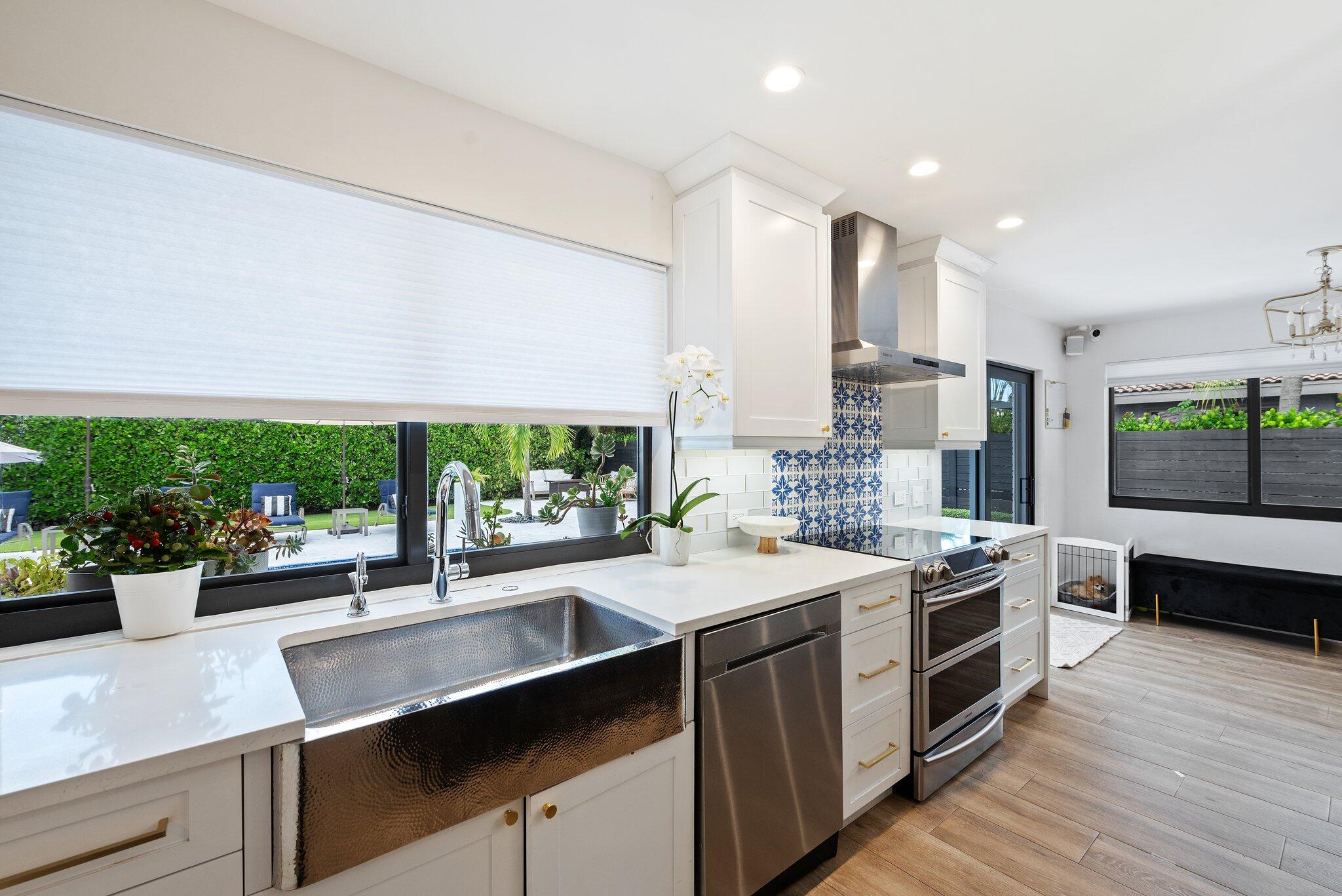 410 Southwest 7th Way Boca Raton, FL 33486 - Photo 4 of 6 a kitchen with a sink stove and cabinets