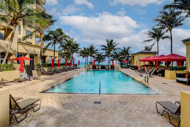 a view of a hall with the floor to ceiling windows and a rug