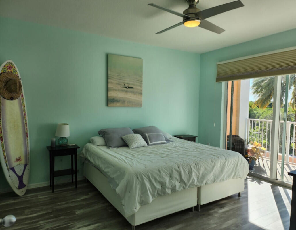 802 West Windward Way, Unit 309 Lantana, FL 33462 - Photo 4 of 10 a bedroom with a bed a window and a chandelier