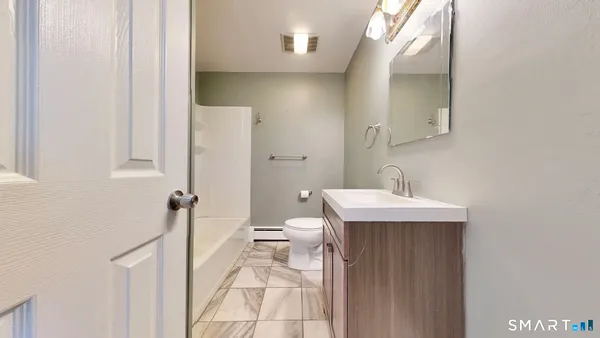 a bathroom with a sink a toilet and a mirror