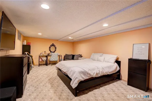 a spacious bedroom with a bed and dresser