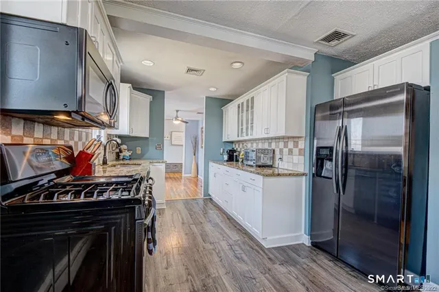 a kitchen with stainless steel appliances granite countertop a stove a refrigerator and a stove
