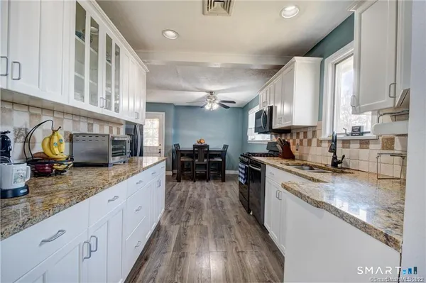 a large kitchen with a lot of counter space and wooden floor