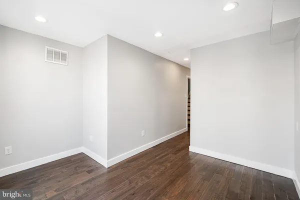 a view of an empty room with wooden floor