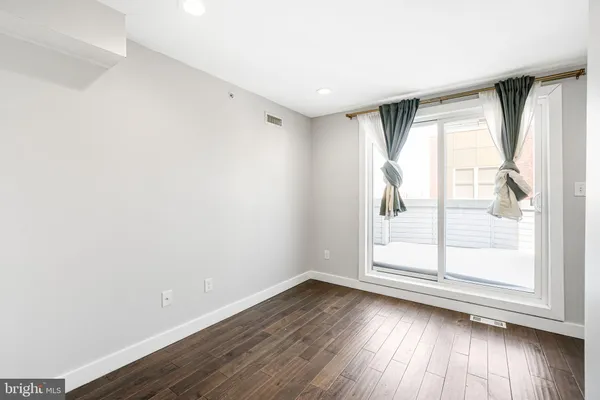 an empty room with wooden floor and door