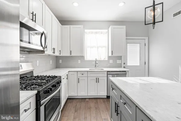 a kitchen with cabinets appliances a sink and a window